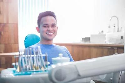 man smiling in the dental chair at Lee Dentistry