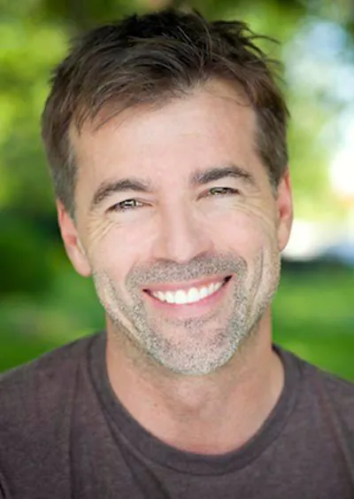 man smiling after a root canal relieved his tooth pain
