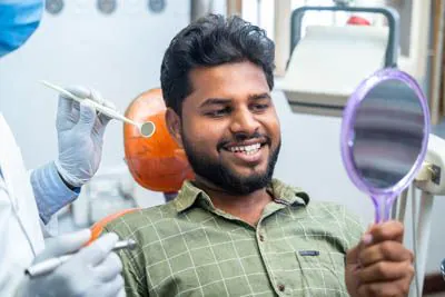 patient smiling in the mirror at Lee Dentistry