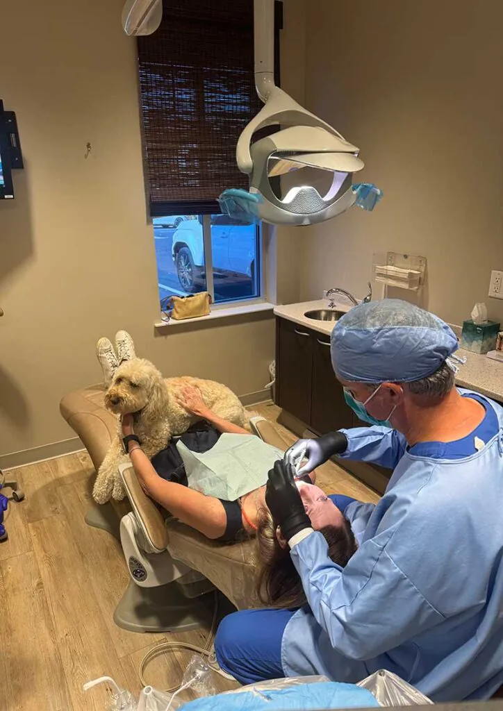 patient with office therapy dog while getting oral surgery procedure